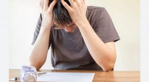 frustrated man holding his head after challenges of genealogy